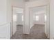 Hallway with carpeting leads to bedrooms with white doors, showcasing the home's layout at 6350 W Hess St, Phoenix, AZ 85043