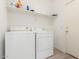 Practical laundry room with washer, dryer, shelving and access door at 6350 W Hess St, Phoenix, AZ 85043