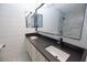 Bathroom with double sinks, white cabinets, black countertop, and shiplap accent wall at 6454 E University Dr # 5, Mesa, AZ 85205