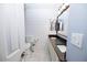 Bathroom with double sinks, white cabinets, black countertop, and shiplap accent wall at 6454 E University Dr # 5, Mesa, AZ 85205