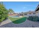 Expansive backyard featuring a sparkling pool, lush green landscaping, and covered patio at 6634 N 16Th Dr, Phoenix, AZ 85015