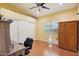 Cozy bedroom features wood floor, ceiling fan, white sliding door closet and desk at 698 W Merrill Ave, Gilbert, AZ 85233