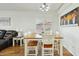 Well-lit dining room features a wood table, six chairs, light wood floors, and window with white shutters at 698 W Merrill Ave, Gilbert, AZ 85233