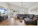 Inviting living room with a large, dark leather sectional, wood floors, and an adjacent entry with screen door at 698 W Merrill Ave, Gilbert, AZ 85233