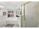 Well-lit primary bathroom featuring double sinks, a soaking tub with a window, and a glass-enclosed shower at 698 W Merrill Ave, Gilbert, AZ 85233