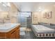 Bathroom with dual vanity sinks, a shower with glass block and a soaking tub at 713 N Banning Cir, Mesa, AZ 85205