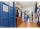 This stylish walk-in closet is enhanced by the blue phone booth style door, built-ins, and natural light at 713 N Banning Cir, Mesa, AZ 85205