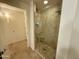 Well-lit bathroom with shower featuring glass door and travertine tile at 7147 E Rancho Vista Dr # 3010, Scottsdale, AZ 85251