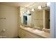 Bright bathroom featuring double sinks, beige cabinets, countertop, and a large mirror at 7147 E Rancho Vista Dr # 3010, Scottsdale, AZ 85251