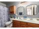 Well-lit bathroom featuring double sinks, wooden cabinets, updated fixtures, and a shower-tub combo at 7322 S Sunset Way, Buckeye, AZ 85326