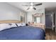 Bright bedroom with shutters, a dresser with a decorative mirror, and a comfortable blue bed at 7322 S Sunset Way, Buckeye, AZ 85326