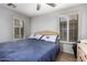 Cozy bedroom with natural light, shutters, wood-look flooring, and comfortable blue bedding at 7322 S Sunset Way, Buckeye, AZ 85326