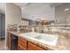 Kitchen sink with tile countertops and stylish faucet, adjacent to sleek black appliances at 7322 S Sunset Way, Buckeye, AZ 85326