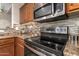 Updated kitchen showcasing stainless steel appliances and a decorative backsplash at 7322 S Sunset Way, Buckeye, AZ 85326