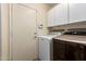 Functional laundry room featuring modern washer and dryer units with additional storage cabinets at 7322 S Sunset Way, Buckeye, AZ 85326