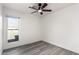 Bright bedroom features a window with a view, ceiling fan, and wood-look floors at 7326 W Georgia Ave, Glendale, AZ 85303