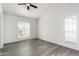 Bright bedroom featuring gray wood-look floors, white walls, and natural light from the windows at 7326 W Georgia Ave, Glendale, AZ 85303