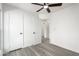 Bright bedroom featuring gray wood-look floors, white walls, ceiling fan, and ample closet space at 7326 W Georgia Ave, Glendale, AZ 85303