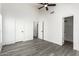 Neutral bedroom with gray wood-look floors, white walls, ceiling fan, and ample closet space at 7326 W Georgia Ave, Glendale, AZ 85303