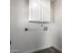 Clean laundry room featuring white walls, gray wood-look floors and white storage cabinet at 7326 W Georgia Ave, Glendale, AZ 85303