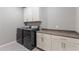 Bright laundry room features gray washer and dryer with white upper and lower cabinets at 7472 E Paraiso Dr, Scottsdale, AZ 85255