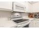 Close-up of a kitchen with white appliances and counters at 7575 E Indian Bend Rd # 1036, Scottsdale, AZ 85250