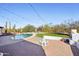 This lovely backyard features string lights, a fire pit, pool, and artificial turf at 7650 E Culver St, Mesa, AZ 85207