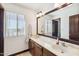 Classic bathroom featuring a double sink vanity, a framed mirror and dark wood accents at 7650 E Culver St, Mesa, AZ 85207