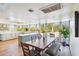 Sunny dining room with a large window overlooking the yard, adjacent to a modern kitchen island with a breakfast bar at 7650 E Culver St, Mesa, AZ 85207