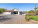 Exterior view showcasing the driveway, garage, tiled roof, desert landscaping, and poolside view at 7650 E Culver St, Mesa, AZ 85207