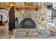 Stone fireplace with wooden mantle and accessories creating a focal point in the living area, with spiral staircase nearby at 7650 E Culver St, Mesa, AZ 85207