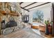 Bright living room featuring a stone fireplace, spiral staircase, large window and beamed ceilings offering lots of natural light at 7650 E Culver St, Mesa, AZ 85207