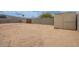 Large, enclosed dirt backyard featuring privacy block walls, shed and shade trees at 8038 S 25Th St, Phoenix, AZ 85042