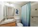 Bathroom featuring single sink vanity, blue shower curtain, and tile surround at 8038 S 25Th St, Phoenix, AZ 85042