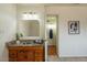 Bathroom featuring granite counters, wood cabinets, and a view into a second full bath at 8038 S 25Th St, Phoenix, AZ 85042