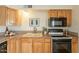 Open kitchen with granite countertops, stainless steel appliances, and wood cabinetry at 8038 S 25Th St, Phoenix, AZ 85042