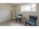 Bright sitting area with large window, tile floors, contemporary rug, stylish chairs and clothing rack at 8038 S 25Th St, Phoenix, AZ 85042