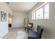 Bright sitting area with large window, tile floors, contemporary rug, stylish chairs and clothing rack at 8038 S 25Th St, Phoenix, AZ 85042