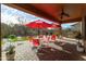 Inviting covered patio featuring brick pavers, bright red umbrellas, and an outdoor kitchen, perfect for entertaining guests at 8157 E Apache Plumb Dr, Gold Canyon, AZ 85118