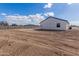 Expansive backyard, graded and ready for landscaping and personalization with a modern home in the background at 9504 W Century Dr, Arizona City, AZ 85123