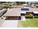 Aerial view of a single-story home showcasing a covered carport, solar panels and landscaped front yard at 10816 W Venturi Dr, Sun City, AZ 85351