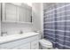 Bathroom with a white vanity and mirror cabinet, paired with a blue and white shower curtain at 10816 W Venturi Dr, Sun City, AZ 85351