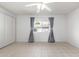 Bedroom with white ceiling fan, tile floors, large window with gray curtains and blinds at 10816 W Venturi Dr, Sun City, AZ 85351
