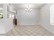 Bright dining room with tile flooring, an elegant chandelier, and views into the kitchen for easy entertaining at 10816 W Venturi Dr, Sun City, AZ 85351