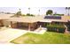 Aerial view of a single-story home featuring a carport, lawn, and gated patio with solar panels at 10816 W Venturi Dr, Sun City, AZ 85351