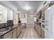 Galley kitchen features tile floors, light wood cabinets, stainless sink and white appliances at 10816 W Venturi Dr, Sun City, AZ 85351