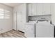 Bright laundry room with cabinets, modern washer, and dryer set at 10816 W Venturi Dr, Sun City, AZ 85351