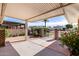 Inviting covered patio with brick accents and views of a charming gated front yard with mature desert landscaping at 10816 W Venturi Dr, Sun City, AZ 85351