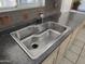 Modern kitchen sink with stainless steel faucet and dark countertop at 10816 W Venturi Dr, Sun City, AZ 85351