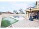 Backyard with a basketball hoop, synthetic grass, a sparkling pool, and a covered patio at 10825 W El Cortez Pl, Peoria, AZ 85383
